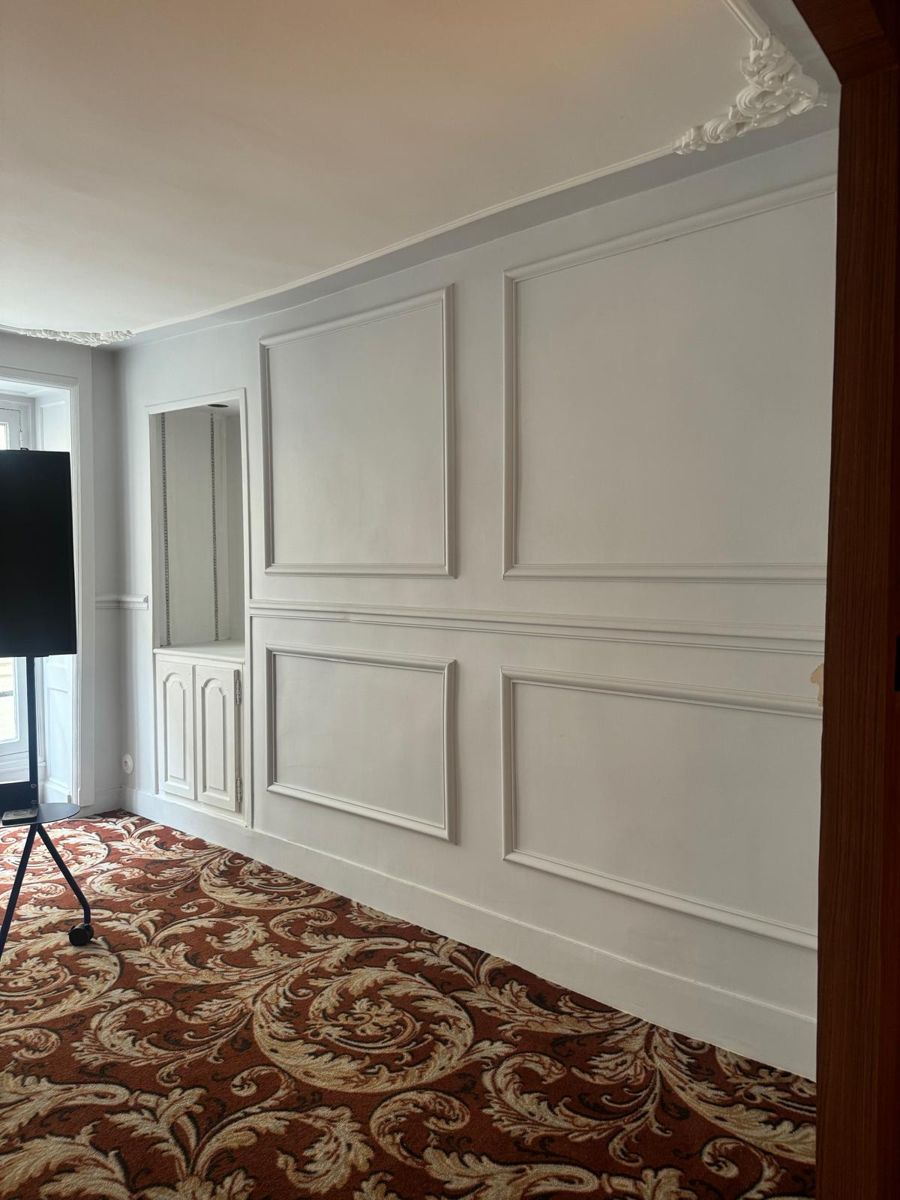 Chambre d'hôtel rénovée — moulures et moquette à motifs, Paris 14e