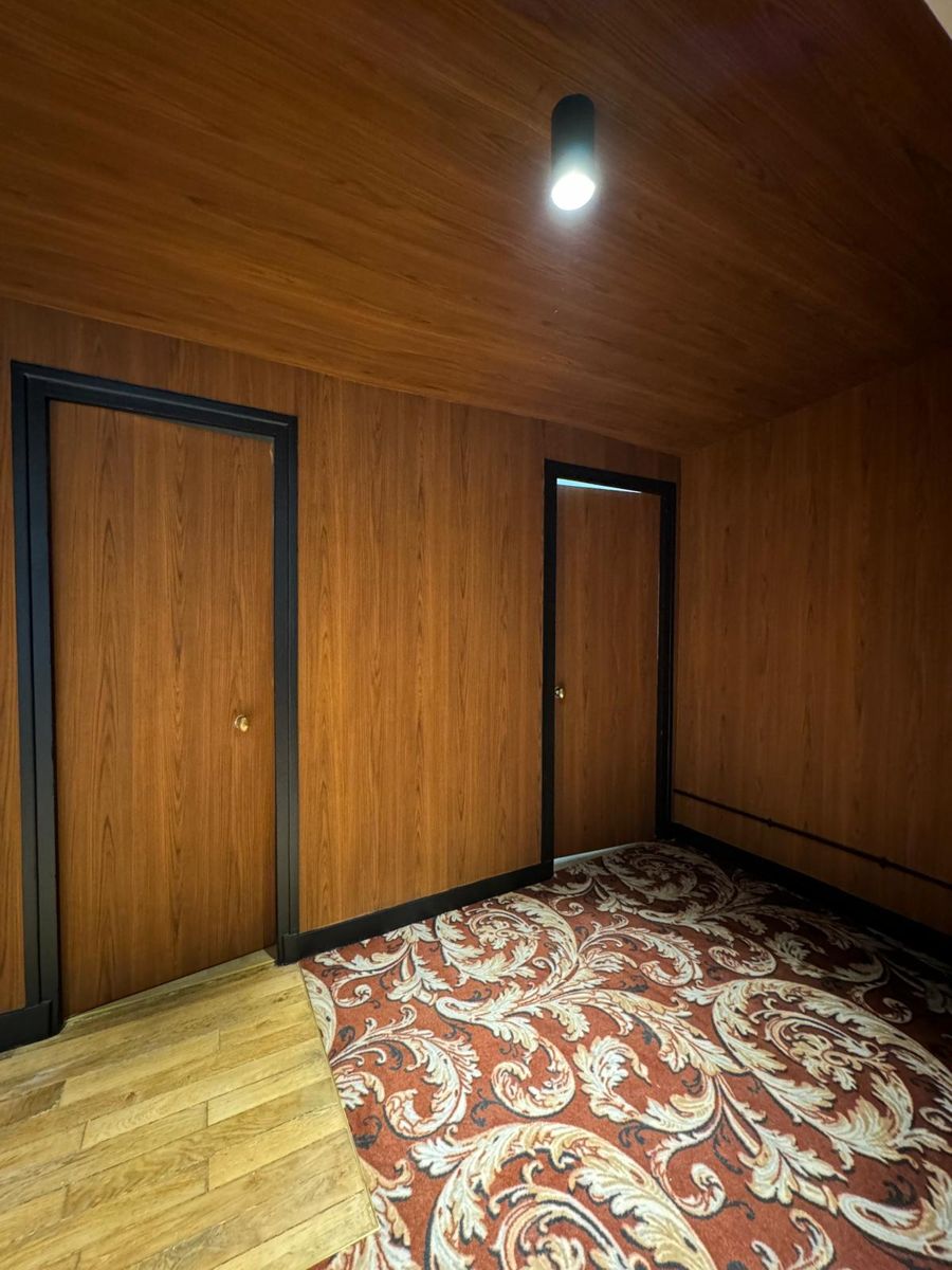 Couloir hôtelier — boiseries acajou et portes noires, Le K Renov
